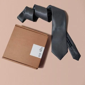 Cravatta da Uomo Grigia Tinta Unita con Quadretti in Rilievo Disegno Geometrico - Imagen 1 de 4