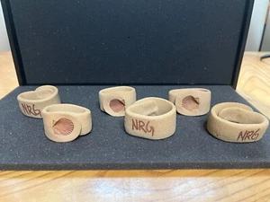 JUEGO DE 6 ANILLOS DE SERVILLETA DE CERÁMICA DE ARCILLA POSIBLEMENTE HECHOS A MANO CONCHA UN LADO "NRG" OTRO - Imagen 1 de 5