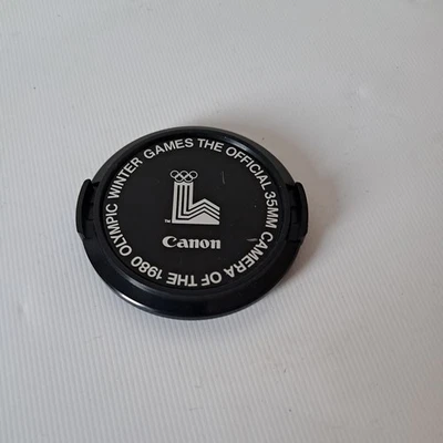 Canon C-52mm The Official 35MM Camera Of The 1980 Olympic Winter Games Lens Cap - Image 1 of 2