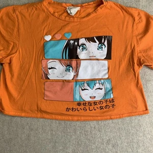 Top corto de pastelería francesa con temática de anime mujer feliz naranja texto japonés - Imagen 1 de 8