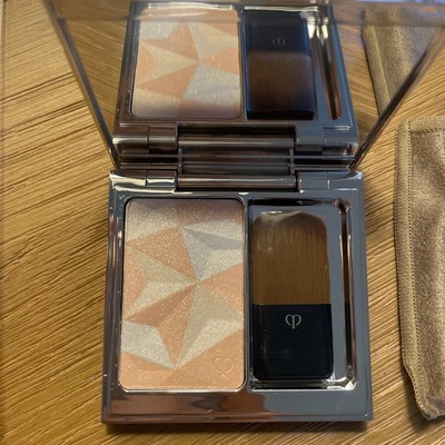 Potenciador facial iluminador Cle de Peau en polvo iluminador naranja-rosa 18 Foto 1 de 4