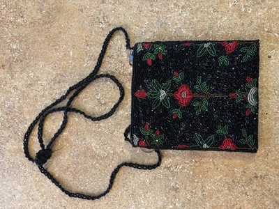 Bolso de mano con cuentas negro con flores rojas y cuentas en ambos lados Foto 1 de 3