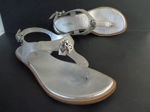 Sandalias planas MICHAEL KORS US 6,5 M Suki plateadas metálicas tanga correa en T con dijes - Imagen 1 de 9