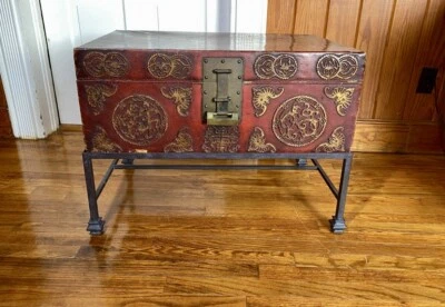 Baúl de viaje de cuero grueso de latón rojo asiático antiguo raro sobre soporte de metal Foto 1 de 4