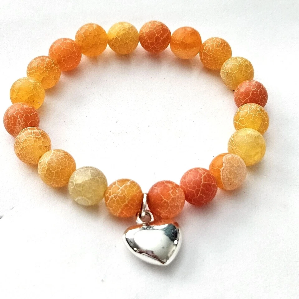 Pulsera elástica con cuentas de ágata naranja con dije de corazón tono plata Foto 1 de 1