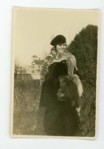 Niña cubierta de múltiples pieles de animales. Foto instantánea vintage - Imagen 1 de 3