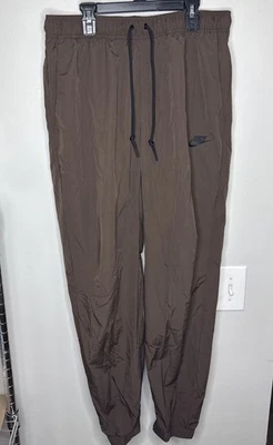Calça Nike Tech tecido perna cônica marrom preta FZ0758-237 masculina tamanho médio - Imagem 1 de 4