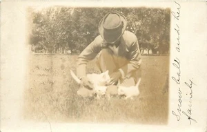 Postal RPPC Fargo ND Hombre se arrodilla por White Cat & Kittens, bola de nieve y su familia - Imagen 1 de 2
