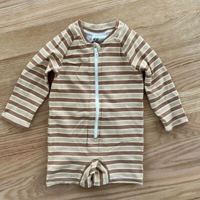 Traje de baño H&M para niños de una pieza protector contra erupciones cremallera marrón melocotón rayas 3-6 meses Foto 1 de 4