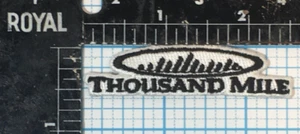 VINTAGE THOUSAND MILE OUTDOOR CLOTHING PROMO BLACK WHITE 2.5" IRON ON PATCH - Picture 1 of 2