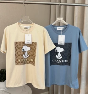NUEVO CON ETIQUETAS COACH Hombre Mujer Unisex AZUL Y AMARILLO Snoopy Camiseta ALGODÓN - Imagen 1 de 11