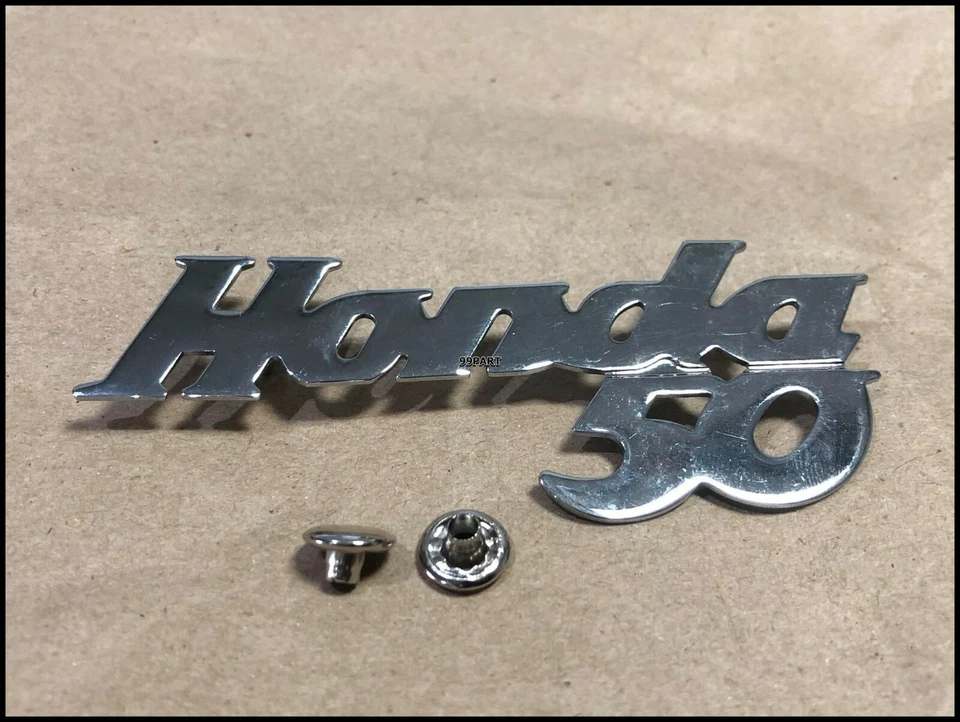 Honda 50 C100 CA100 C102 CA102 C50 emblema protector de pierna CUBIERTA DELANTERA protector de pierna NUEVO Foto 1 de 3