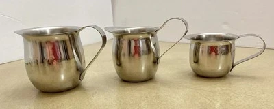 Juego de tres jarras crema de acero inoxidable de diferentes tamaños Foto 1 de 4