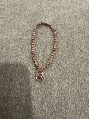 Pulseira elástica com miçangas em tom de ouro rosa Michael Kors com logotipo e charme de cadeado - Imagem 1 de 3