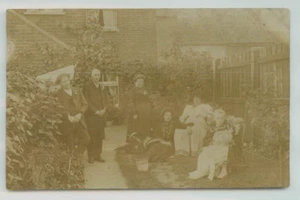 POSTCARD Family photo sitting in the garden 1900s RPPC - Picture 1 of 2