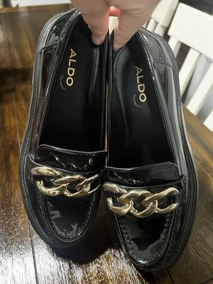 Mocasines ALDO negros y dorados con hebilla decorativa para mujer Foto 1 de 4