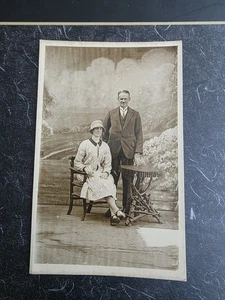 COUPLE SAT AT TABLE & CHAIR, BLACKPOOL 1928, STAGED REAL PHOTO POSTCARD - Picture 1 of 6