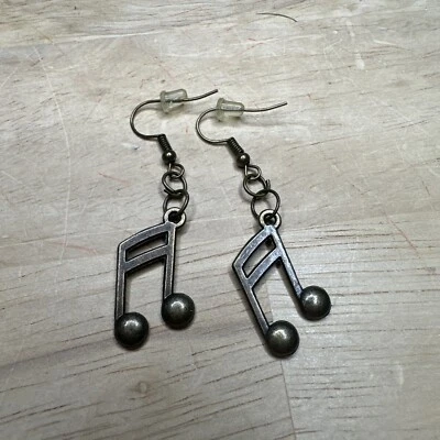 Bronze Plated Costume Jewelry Music Note Earrings With Rubber Posts On Cardstock - Image 1 of 3