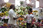 African American Mother gives child a flower in store Poster Print... 