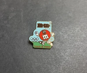 M&M SPONSOR TRACK & FEILD OLYMPIC GAMES PIN BADGE TOKYO JAPAN Vintage - Bild 1 von 3