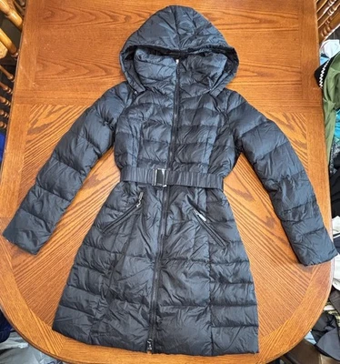 Abrigo acolchado de plumón para mujer Benetton negro pequeño con cinturón largo capucha extraíble Foto 1 de 4