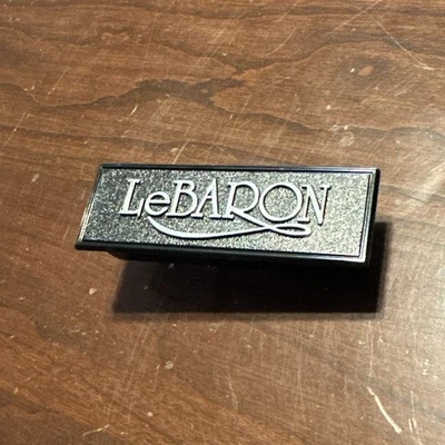 Insignia emblema tablero Chrysler Lebaron 1982-88 04220830 OEM  Foto 1 de 2