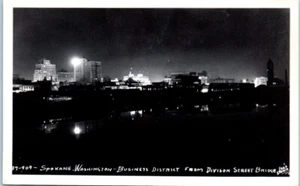 DISTRITO DE NEGOCIOS de Division Street SPOKANE, WA vista nocturna RPPC postal - Imagen 1 de 2