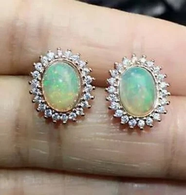 Aretes con halo de diamantes de ópalo de fuego de corte ovalado de 4 quilates de oro amarillo de 14 quilates Foto 1 de 4