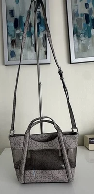 Bolso Bandolera Calvin Klein Monograma Panel Transparente Marrón Taupe Logo CK Pequeño Foto 1 de 4