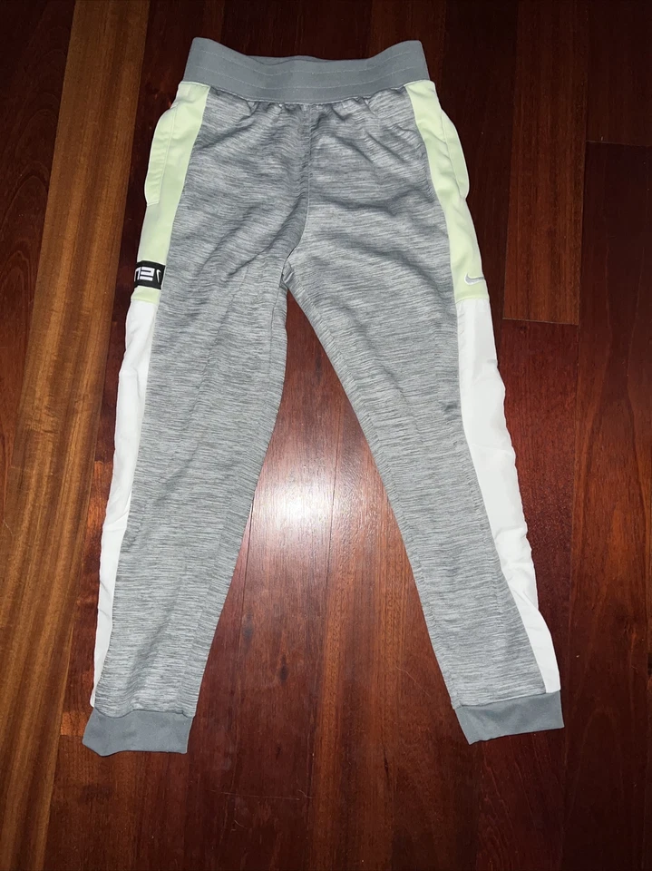 Pantalones deportivos Nike Therma-Fit grises, verdes y blancos grandes para niños Foto 1 de 4