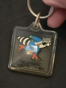 XIII Olympische Winterspiele 1980 Acryl Schlüsselanhänger Eislaufen Waschbär See Placid - Bild 1 von 5