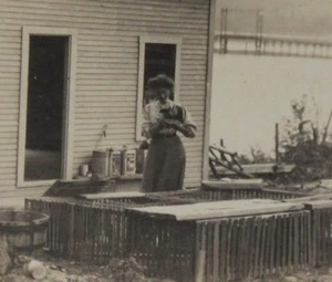 1910 RPPC espalda dividida sepia sin publicar mujer junto al lago casa alimentación animales - Imagen 1 de 4
