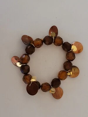 Pulsera elástica de plástico marrón/ámbar naranja con colgantes de carcasa Foto 1 de 4