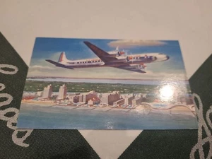 Eastern Airlines Golden Falcon DC-7B Airplane Flying Over Miami Beach Postcard - Picture 1 of 3