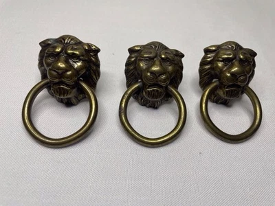 Tiradores antiguos vintage de tres cabezas de león de latón. Foto 1 de 4