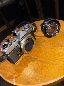 Appareil photo reflex argentique Olympus OM-1 MD - noir argent OEM bracelet vintage manque bouton - Photo 1/13
