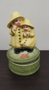 Vintage Japan Ceramic Rotating Music Box Figurine Children In Yellow Raincoats - Picture 1 of 6