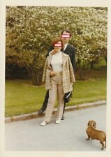 Foto Bildhübsche Frau mit Mann in Mode der 70er Jahre Hund Dackel Momentaufnahme