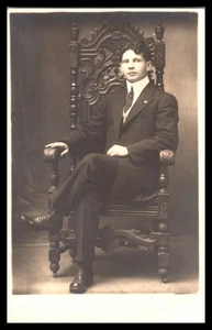 RPPC Hombre en traje en silla tallada ornamentada estudio retrato AZO respaldo dividido postal - Imagen 1 de 2