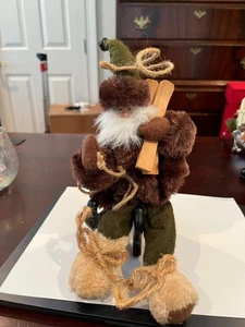 Santa Ornament Dressed Brown and Green Holding Skis - Picture 1 of 4