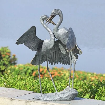 Dos hermosas y elegantes grúas de cortejo suave abrazo jardín escultura Foto 1 de 2