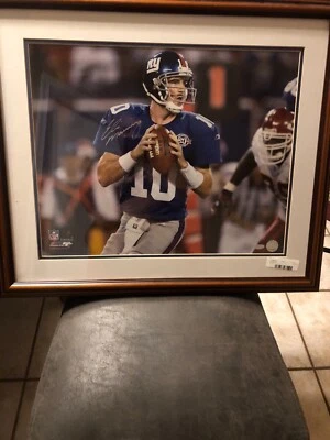 Eli Manning Autographed 20x16 framed photo in a 27x23 wood finished frame - Image 1 of 3