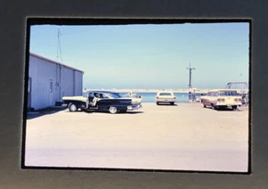 Automóviles vintage de viaje de los años 60 cerca del muelle Ford de los años 50 - Imagen 1 de 3