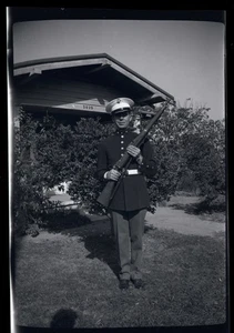 BLACK & WHITE NEGATIVE * Man in uniform holding his rifle in front of house - Picture 1 of 3