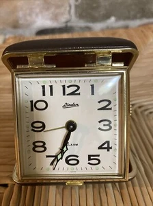 Reloj despertador de viaje vintage tilo dorado manecillas y puntos marrón estuche con almeja usado en excelente estado - Imagen 1 de 5