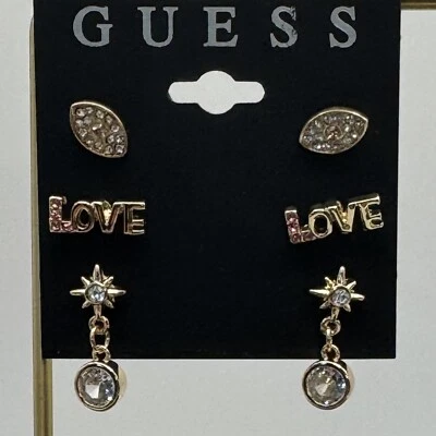 Juego de 3 pendientes de tachuelas surtidas Guess tono dorado-amor-mal de ojo Foto 1 de 3