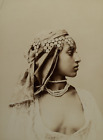 Jeune femme algérienne de profil, un bijou de tête et colliers de perles. Algéri