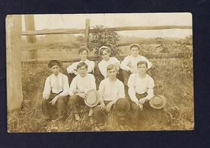 RPPC de principios de 1900, grupo de niños vestidos tomando una foto por una cerca de granja - Imagen 1 de 2