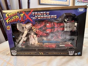 TRANSFORMERS X STREET FIGHTER II OPTIMUS PRIME RYU VS. MEGATRON M. BISON TAKARA - Picture 1 of 7