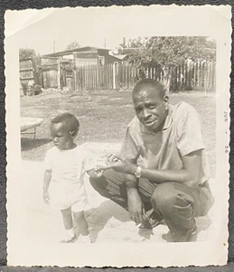 Young Black Father in Backyard w Tiny Son Holding His Finger-1956 Snapshot Photo - Picture 1 of 3